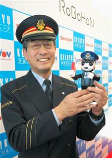 ロボット型携帯電話「ロボホン」を手に笑顔を見せる京浜急行の担当者＝２２日、東京都大田区