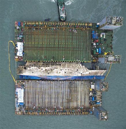 引き揚げ作業で海面に浮上したセウォル号（中央）＝２４日、韓国南西部の珍島沖（代表撮影・共同）