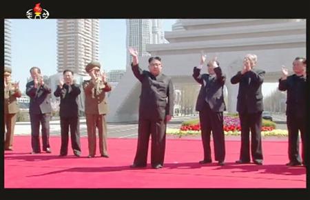 高層住宅団地の竣工式に出席し、手を振る金正恩朝鮮労働党委員長（中央）。北朝鮮の朝鮮中央テレビが放映した＝１３日、平壌（共同）