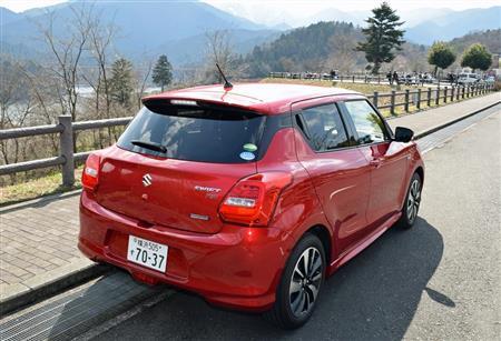 スイフトのリヤビュー。塗装の陰影感もきれい。奥にはバイクツーリング中に休憩する人たちの姿も