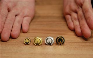 勤続年数により素材が異なる大和ハウス工業の社章。左から勤続４０年のプラチナ、同３０年の金、同２０年の銀、２０年未満の一般的な合金のもの＝２５日、東京・飯田橋の大和ハウス工業東京本社（高橋裕子撮影）