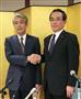 京セラの山口悟郎会長（左）と握手する谷本秀夫社長＝２月２０日、京都市