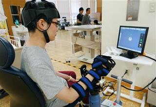 帝人ファーマのロボットでリハビリを行う男性患者＝大阪府豊中市の関西リハビリテーション病院