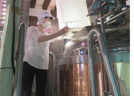 仕込みを体験する筆者。釜に囲まれとんでもなく暑い