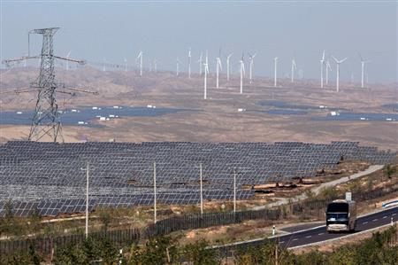 風力発電所とソーラーパネルが敷き詰められた農村を走るバス＝２０１５年１０月、中国・寧夏回族自治区（ＡＰ）