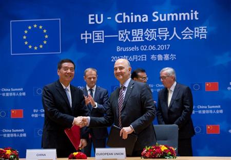 中国の担当者と握手を交わす欧州連合（ＥＵ）の経済財政担当、ピエール・モスコビッシ氏＝２日、ブリュッセル（ＡＰ）