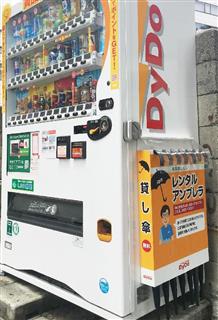 無料レンタル傘を備え付けたダイドードリンコの自動販売機＝大阪市
