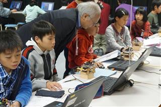 プログラミングを学ぶ児童。指導者を確保することが課題だ＝２０１６年１２月、山口市立大殿小学校（総務省提供）