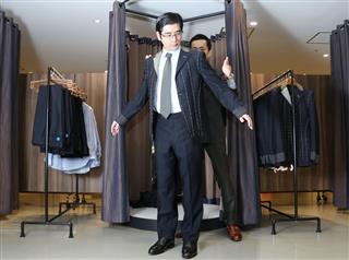 店舗では採寸用のジャケット、ゲージ服を着て測る＝オンリー日比谷店（東京都千代田区）