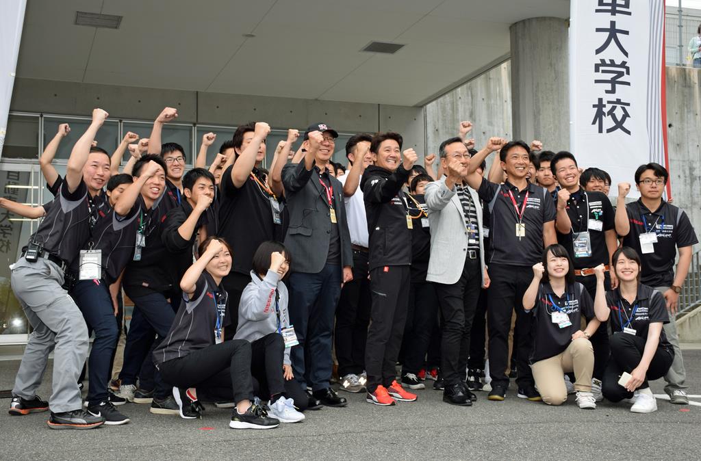 学生たちと記念写真に収まる（中央右から）中村公泰副社長、近藤真彦監督、今西朗夫学長