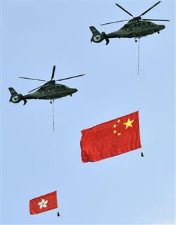 返還から２０年を迎えた香港で、上空に掲げられた中国国旗（右）と香港の旗＝１日（共同）