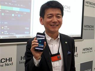 名札型ウエアラブルセンサーを身に着ける日立研究開発グループ技師長の矢野和男氏