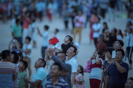 「長征５号遥２」の打ち上げを見上げる人たち＝２日、海南省（ロイター）