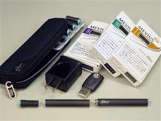 加熱式たばこ「プルームテック」。本体（手前右）からの電気でカートリッジ（中）内の液体を加熱、たばこカプセル（左）を通った蒸気を吸う仕組みだ