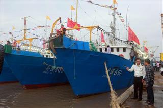 浙江省舟山市にある港で出境手続きをする遠洋漁船。船団を組み、北太平洋でイカ釣りを行うという（中国新聞社）