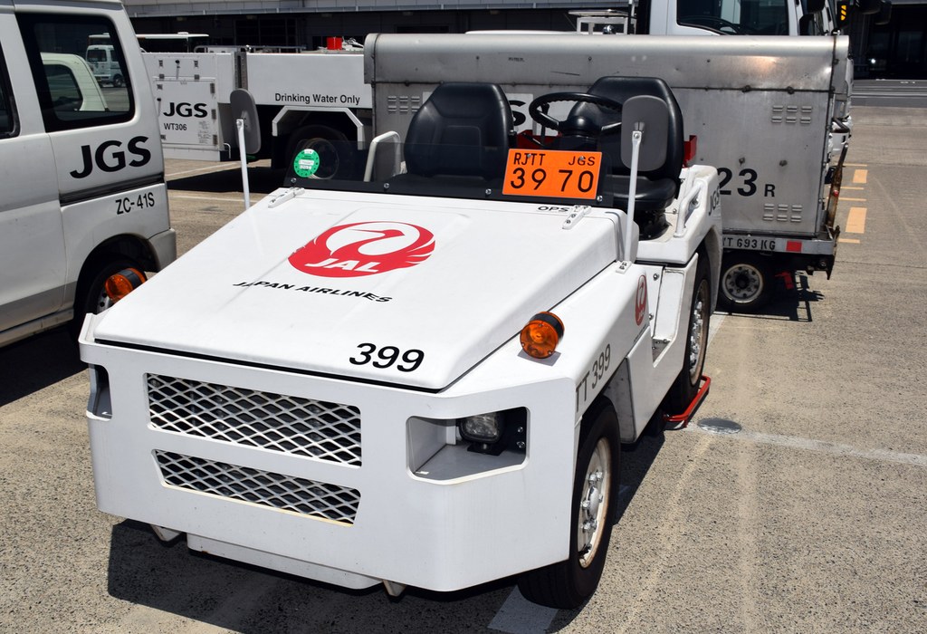 貨物列車のように、連結した荷台にコンテナを積んで走るトーイングトラクター。飛行場でヘビのように走っているあのクルマだ