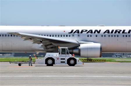 プッシュバックを終えて片付けをする酒井さんの横を、滑走路に向けて走り出した鹿児島行の航空機