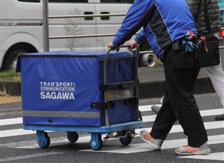 配送する佐川急便の担当者＝東京都内