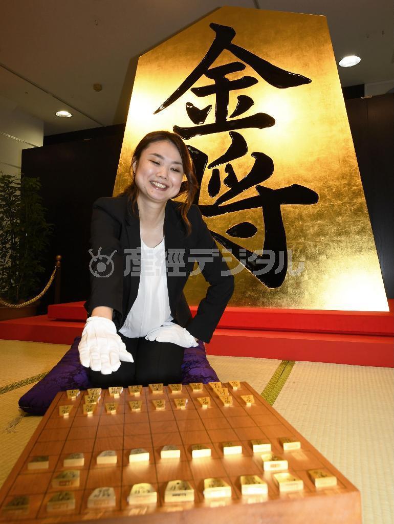 高島屋大阪店の「黄金フェア」でお披露目された巨大な「金将」駒（後方）と純金製の将棋駒セット（手前）＝２６日午前、大阪市