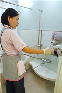 浴室の掃除をするダスキンのフィリピン人女性の従業員＝６月、大阪市内のマンション