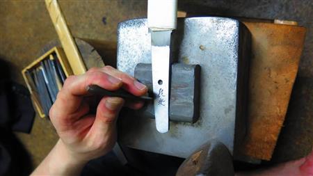 刀の持ち手である茎に銘をきる＝東京都、水木氏の自宅工房（高原大観撮影）