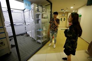 中国の新興企業「享睡空間」が作った昼寝専用のカプセルホテルで入室を待つ女性。ＩＴ関連の専門職をターゲットにしている。中国には昼寝の習慣があるほか、ホワイトカラーの過重労働が深刻な問題となっており、拡大を続ける「シェアリング・エコノミー」の一種として注目を集めているようだ（ロイター）