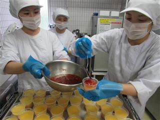 近畿大農学部の学生が育てたミニトマトを使い、デザートを調理する同学部の学生ら＝奈良県生駒市乙田町の近大医学部奈良病院