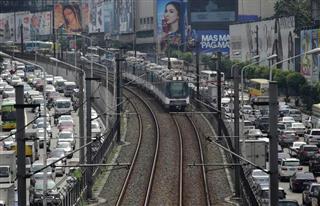 自動車の渋滞時間帯に首都マニラを走る鉄道車両。フィリピンは、渋滞対策が経済課題と指摘されて久しい（ＡＰ）