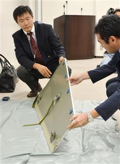 茨城県稲敷市で見つかった航空機のパネルを確認する全日空の関係者=27日夜、成田空港 茨城県稲敷市で見つかった航空機のパネルを確認する全日空の関係者=27日夜、成田空港