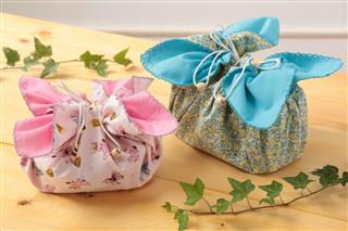 ヒット商品となった「お弁当袋になっちゃう！！ランチクロス☆」。ひもを引っ張るだけで弁当箱を包むことができる