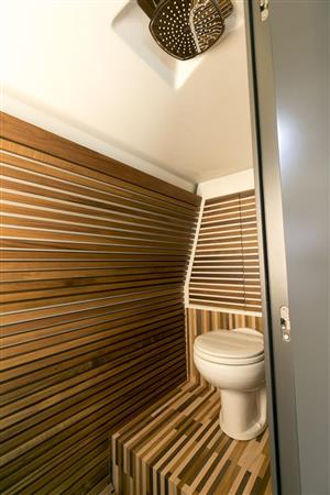 木材をふんだんに使用したＷＣ兼シャワールーム。シャワーは高級ホテルに多いオーバーヘッドタイプだ