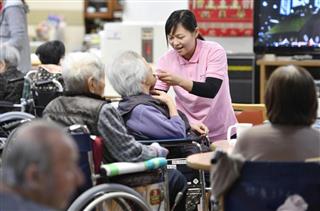 利用者の食事の世話をするナンシーさん＝４月、奈良県天理市
