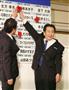 当選確実となった候補者の名前に花を付ける立憲民主党の枝野幸男代表（右）と長妻昭代表代行＝２２日午後、東京都港区（古厩正樹撮影）