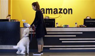 自分の飼い犬にエサを与える従業員。アマゾンは２３８の都市・地域から誘致を受けていると明らかにしている＝１１日、米シアトル（ＡＰ）