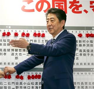 開票速報場で当確のバラを付ける安倍晋三首相（右）＝２２日午後、東京・永田町の自民党本部（松本健吾撮影）
