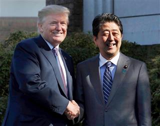 初来日したトランプ米大統領（左）を出迎え、握手する安倍首相＝５日午後、埼玉県川越市の霞ケ関カンツリー倶楽部（ロイター＝共同）