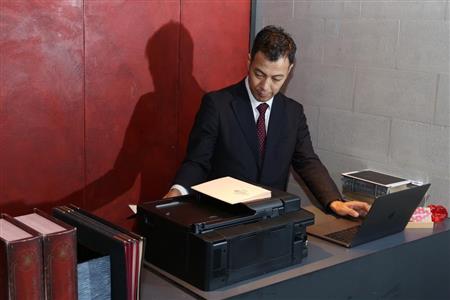 開店前にメニューを印刷する岸マネージャー