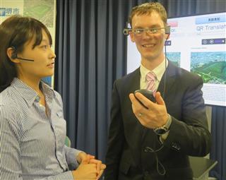 メガネ型翻訳機「コムスメガネ」を使って会話する外国人ら