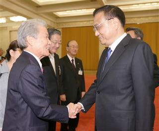 中国の李克強首相（右）との会談を前に、握手する経団連の榊原定征会長＝２１日、北京の人民大会堂（代表撮影・共同）