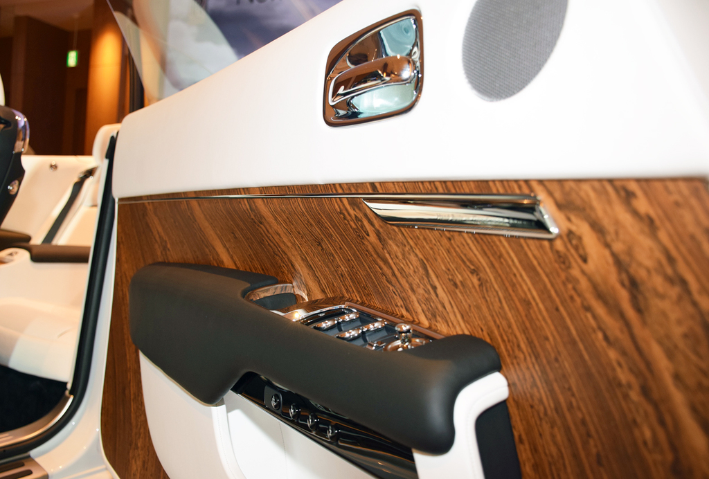 ホワイトレザー、金属パーツ、ウッドの異なる３素材を巧みに組み合わせている