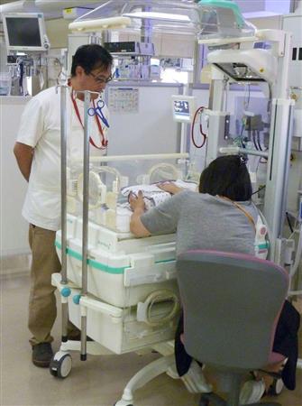 赤ちゃんの様子を見る長野県立こども病院の広間武彦医師＝長野県安曇野市