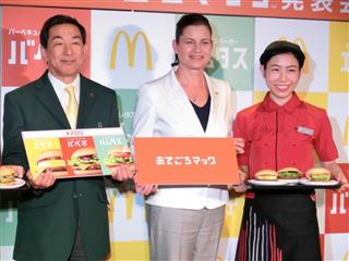 新メニューの発表会見で店員らと写真撮影に応じるサラ・カサノバ社長（中央）＝２０１５年１０月、東京都内