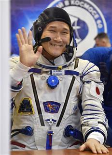 ソユーズ宇宙船の打ち上げを前に、ガラス越しに家族と会話し手を振る金井宣茂さん＝１７日、カザフスタン・バイコヌール（共同）