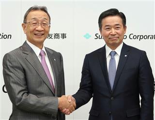 住友商事の中村邦晴社長（左）と握手する、次期社長の兵頭誠之専務執行役員＝２２日午後、東京都中央区