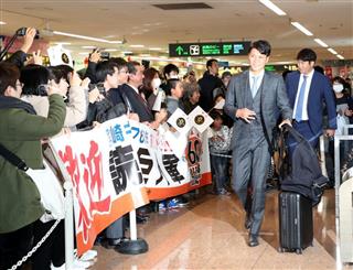 キャンプインを控え合同自主トレのため宮崎入りした巨人・坂本勇人。後ろは菅野智之＝２７日、宮崎空港