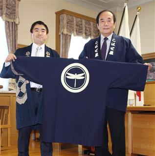 「陸王」で使用されたはんてんのレプリカを埼玉県の上田清司知事（右）に贈る小島染織工業の小島秀之社長＝２０１７年１２月２５日、埼玉県庁（川上響撮影）