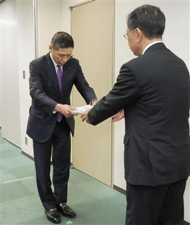 国交省の奥田哲也自動車局長(右)に報告書を提出する日産自動車の西川広人社長=17日午後、国交省 国交省の奥田哲也自動車局長(右)に報告書を提出する日産自動車の西川広人社長=17日午後、国交省