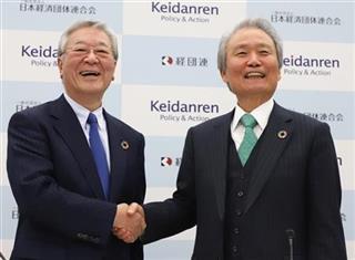 会見後、経団連の榊原定征会長（右）と握手する中西宏明次期会長＝東京都千代田区（飯田英男撮影）