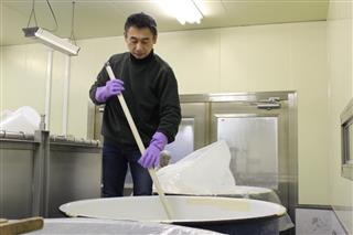 マンション地下の酒蔵でタンクを混ぜる原純社長 マンション地下の酒蔵でタンクを混ぜる原純社長