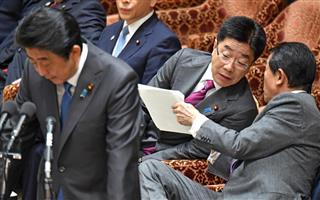 衆院予算委員会で答弁する安倍晋三首相（左）。後ろは麻生太郎副総理兼財務相（右）と話す加藤勝信厚生労働相。野党はこの日も裁量労働制に関するデータ不備を追及した＝２２日午後、衆院第１委員室（斎藤良雄撮影）